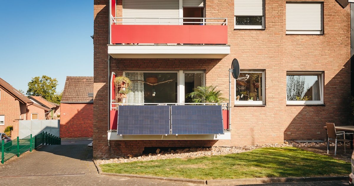 Balcony with solar panels on brick building