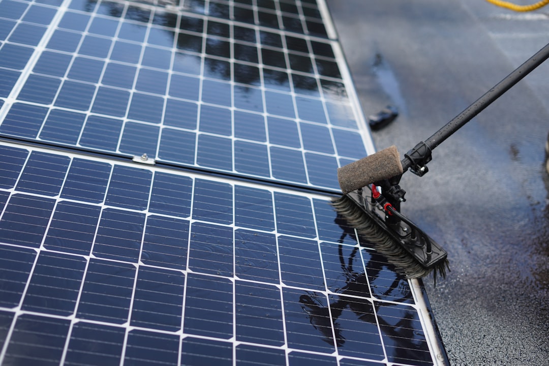 Person cleaning a solar panel with a squeegee