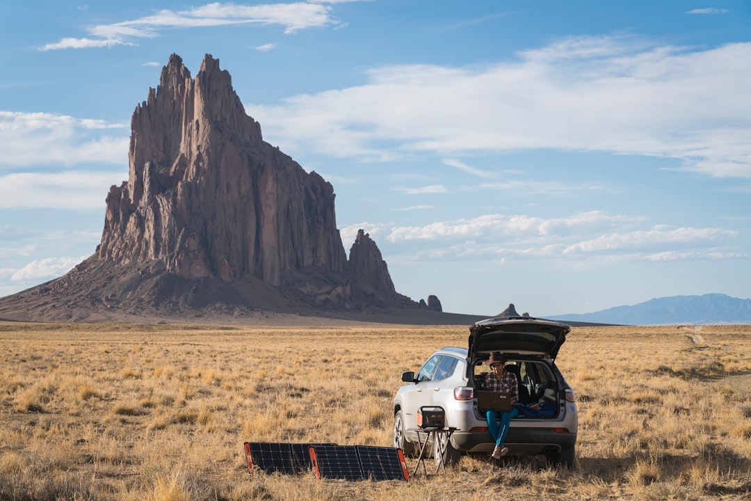 Camper van with solar panels on the roof in a sunny mountain landscape